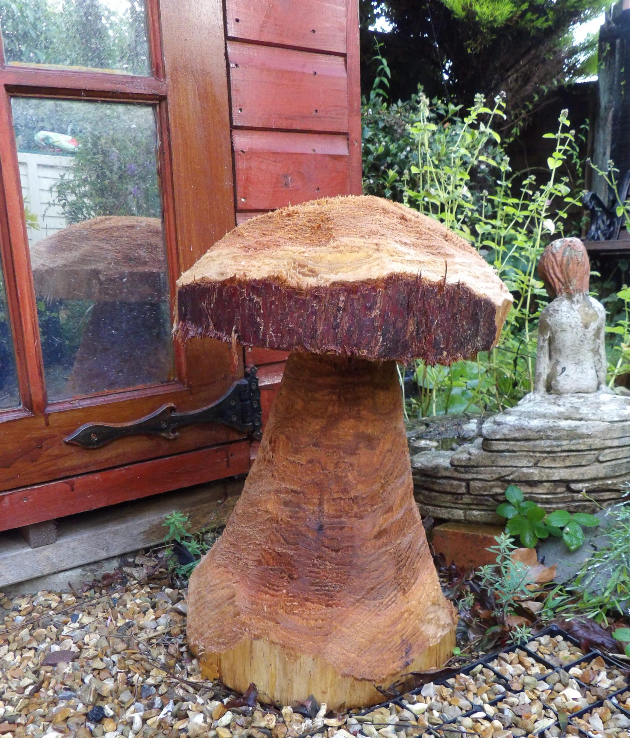 Hand-carved wooden mushroom sculpture created by a volunteer from leftover tree trunk at Howes Wood, Isle of Wight Red Squirrel Trust.