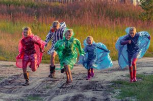 Alt text: Children taking part in an outdoor nature activity in woodland